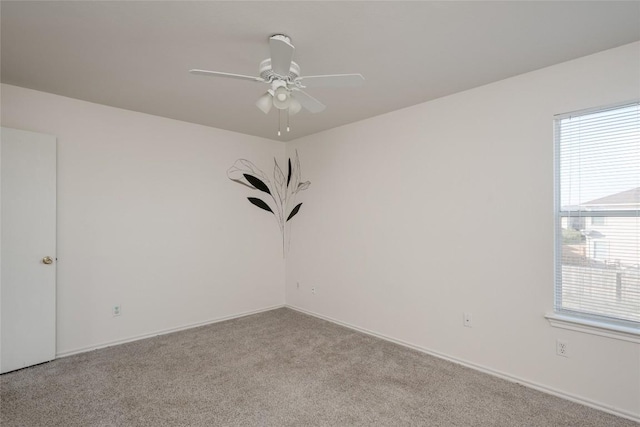 spare room featuring plenty of natural light, ceiling fan, and light colored carpet