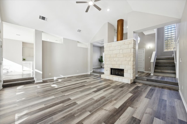 unfurnished living room featuring a fireplace, hardwood / wood-style floors, high vaulted ceiling, and ceiling fan