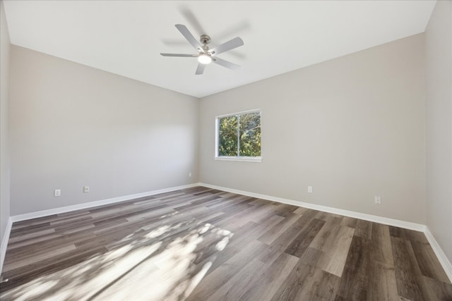 spare room with ceiling fan and dark hardwood / wood-style flooring