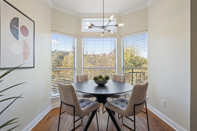 dining space with crown molding, a healthy amount of sunlight, an inviting chandelier, and dark wood-type flooring