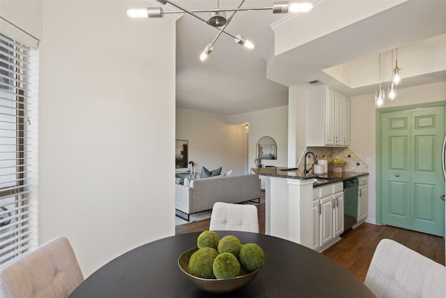 kitchen with dishwasher, white cabinetry, sink, dark hardwood / wood-style flooring, and kitchen peninsula