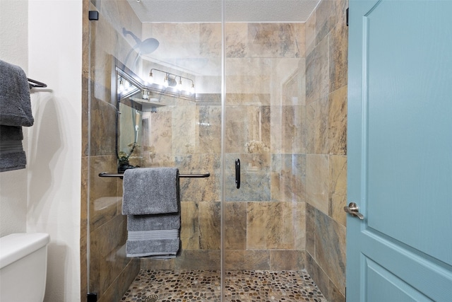 bathroom with a shower with door and toilet