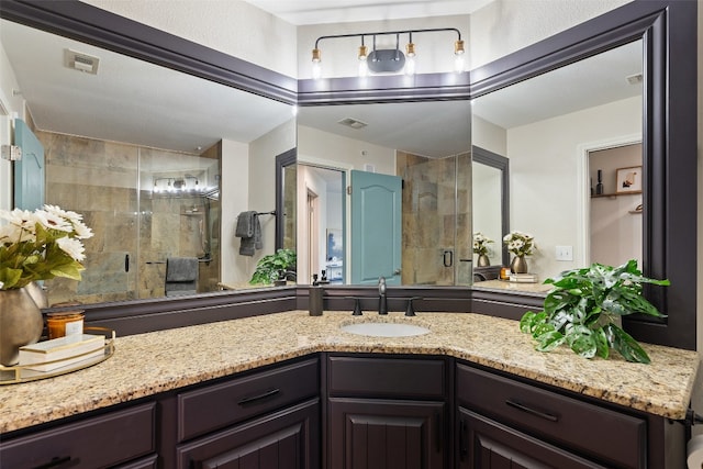 bathroom with vanity and a shower with shower door