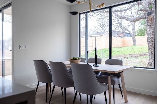 dining area with hardwood / wood-style flooring and a notable chandelier