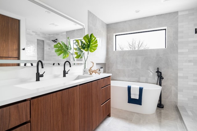 bathroom featuring tile patterned flooring, vanity, tile walls, and shower with separate bathtub