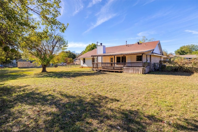 rear view of property featuring a wooden deck and a yard