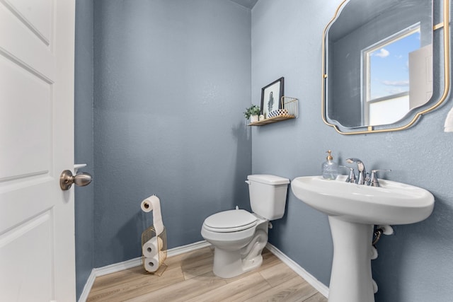 bathroom with hardwood / wood-style floors and toilet