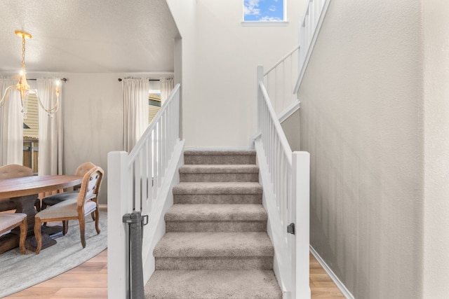 stairs with a textured ceiling and hardwood / wood-style flooring