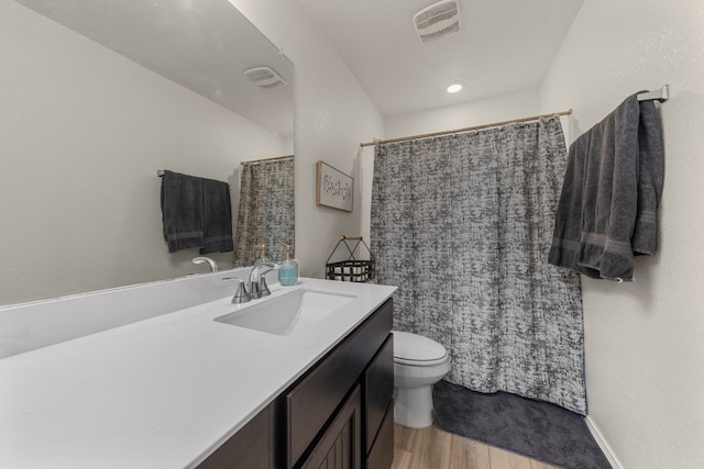 bathroom with a shower with curtain, vanity, wood-type flooring, and toilet