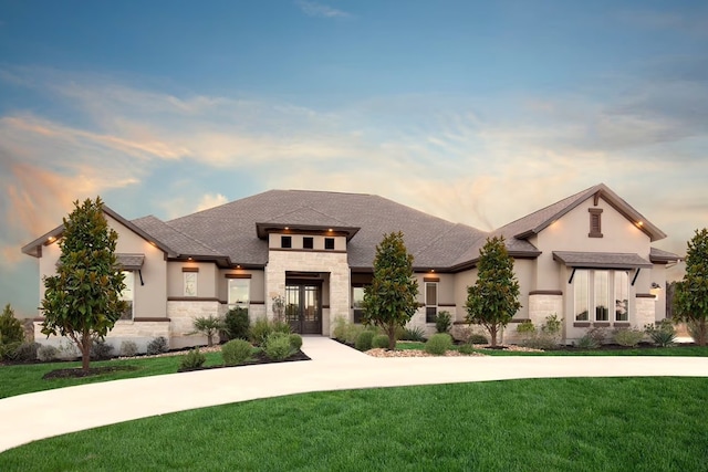 view of front of house with a lawn and french doors