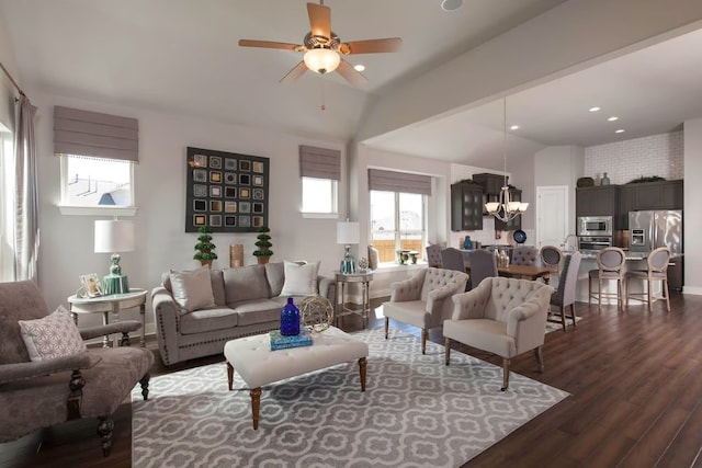 living room featuring ceiling fan with notable chandelier, dark hardwood / wood-style floors, and lofted ceiling