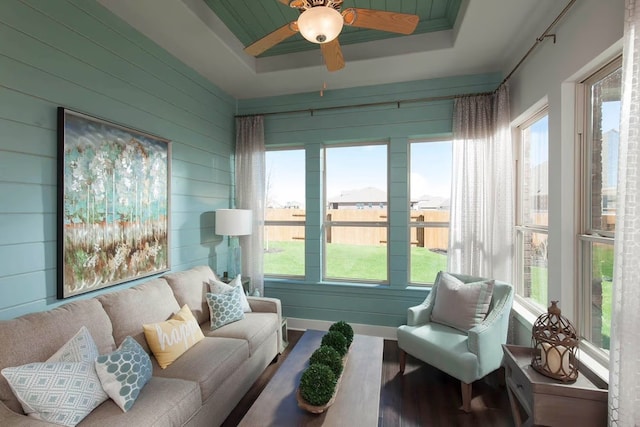 sunroom with a tray ceiling and ceiling fan