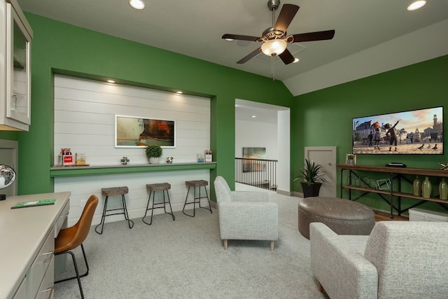 carpeted living room featuring ceiling fan and vaulted ceiling