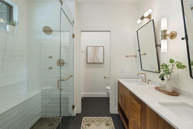 bathroom featuring tile patterned flooring, vanity, toilet, and a shower with door