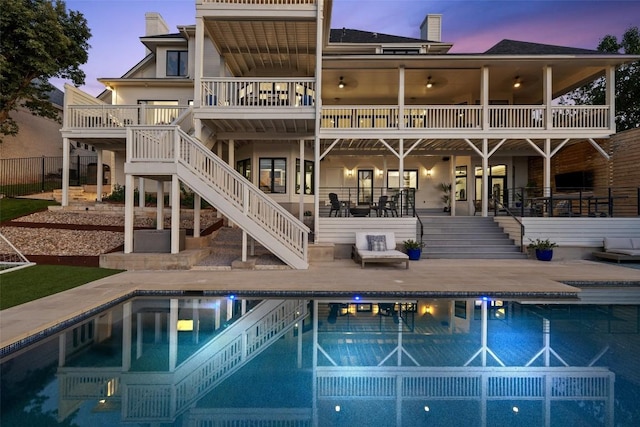 back of property with stairs, a chimney, fence, and a patio area