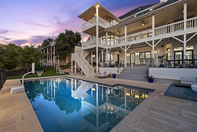 pool at dusk featuring a patio area