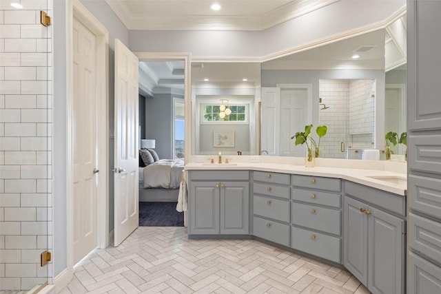 ensuite bathroom featuring connected bathroom, a sink, ornamental molding, a shower stall, and double vanity