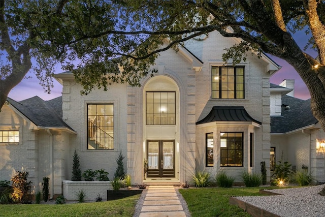 view of front of home featuring a yard and french doors