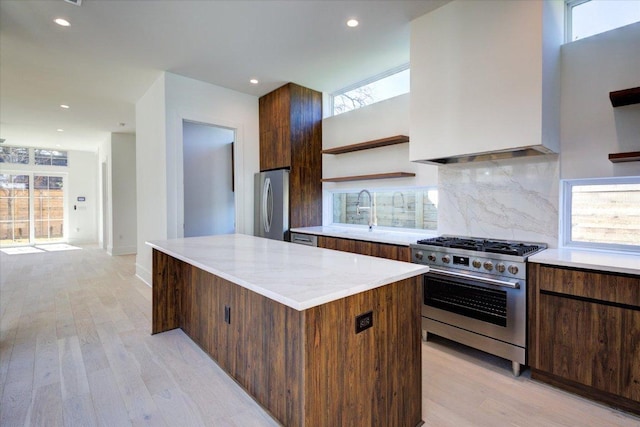 2618 E 4th St, Austin, TX 78702 - kitchen with stainless steel appliances, open shelves, light wood-style floors, a sink, and tasteful backsplash