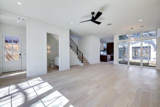 2618 E 4th St, Austin, TX 78702 - unfurnished living room featuring plenty of natural light, light wood-style floors, baseboards, stairs, and recessed lighting
