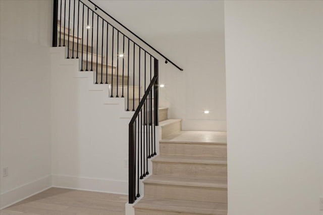 stairs with baseboards and wood finished floors