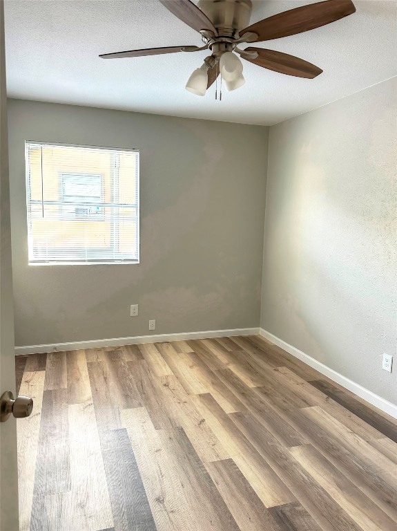 spare room with ceiling fan and wood-type flooring