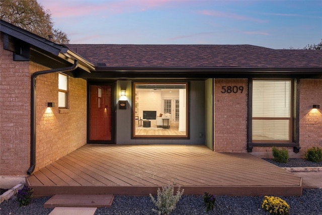 exterior entry at dusk with a wooden deck