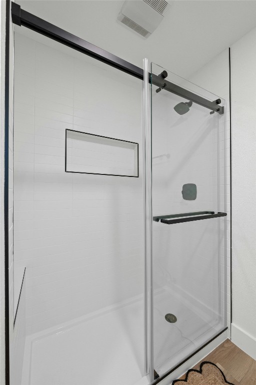 bathroom featuring wood-type flooring and a shower with door