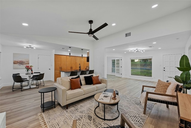 living room featuring ceiling fan, light hardwood / wood-style flooring, and lofted ceiling