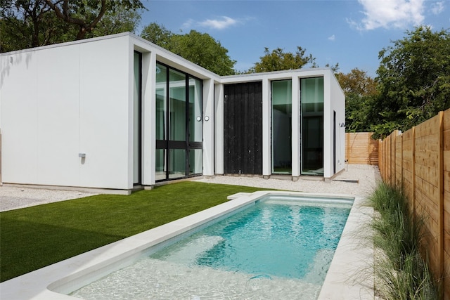 back of property featuring a fenced in pool and a yard