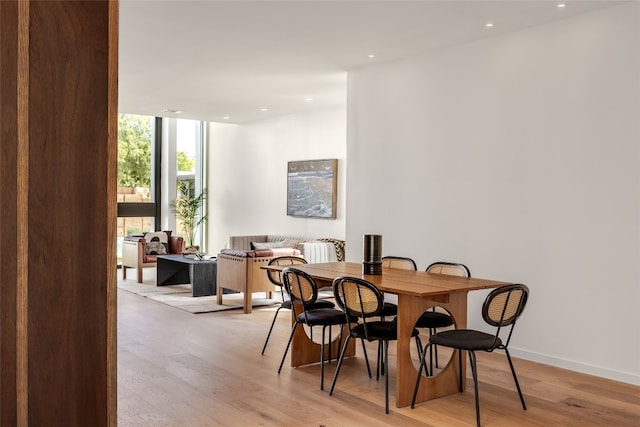 dining space featuring floor to ceiling windows and light hardwood / wood-style flooring