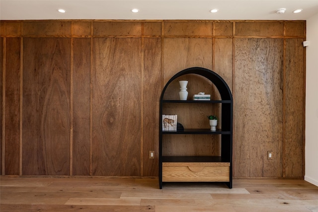 interior details featuring wood walls and hardwood / wood-style flooring