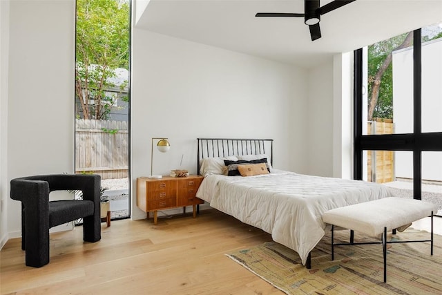 2114 Lawnmont Ave, Austin, TX 78756 - bedroom featuring light wood-type flooring, a wall of windows, and ceiling fan