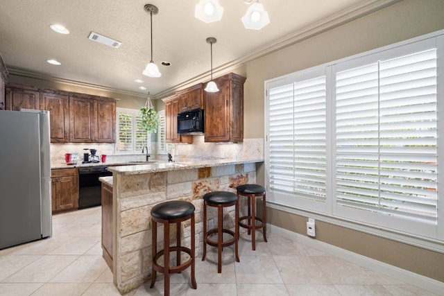 kitchen featuring a breakfast bar, black appliances, decorative backsplash, light stone countertops, and kitchen peninsula