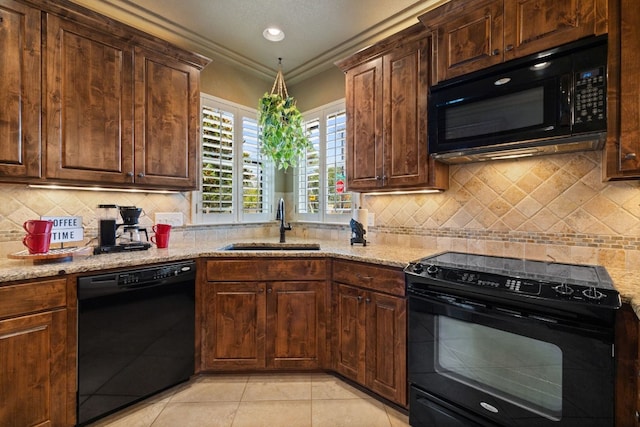 kitchen with backsplash, light stone counters, light tile patterned floors, and black appliances