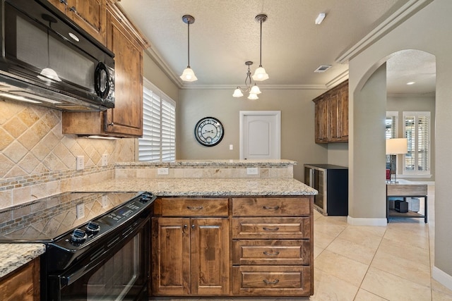 kitchen featuring backsplash, light stone counters, crown molding, black appliances, and light tile patterned flooring