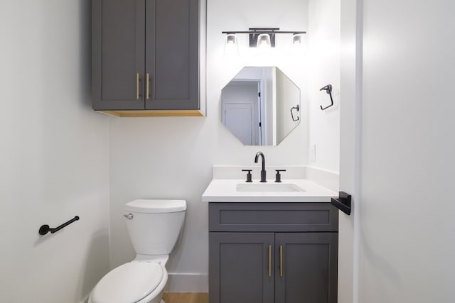 bathroom with hardwood / wood-style floors, vanity, and toilet