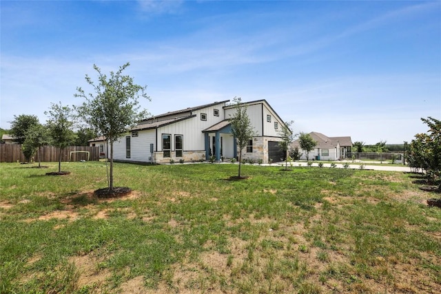 287 La Fortuna Dr, Del Valle, TX 78617 - back of house featuring concrete driveway, stone siding, and a garage