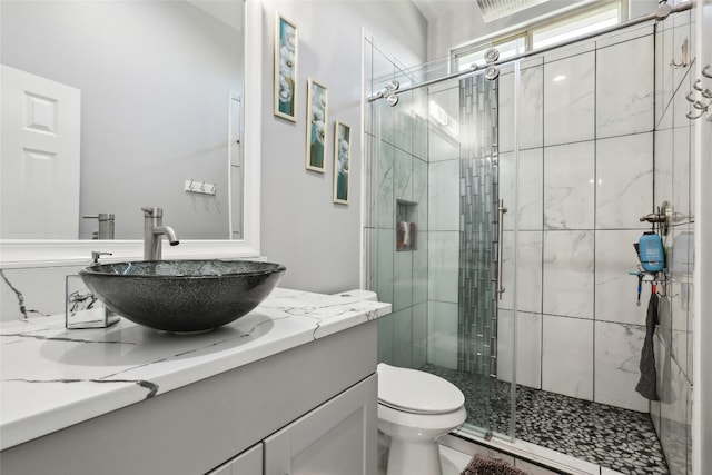 bathroom with toilet, an enclosed shower, and vanity