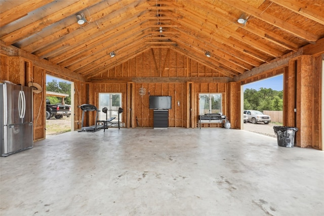 miscellaneous room featuring high vaulted ceiling and concrete flooring