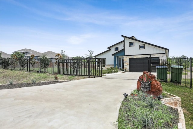 287 La Fortuna Dr, Del Valle, TX 78617 - view of front facade with driveway, a garage, stone siding, and board and batten siding