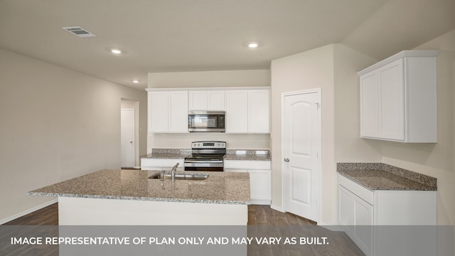 kitchen with appliances with stainless steel finishes, dark hardwood / wood-style flooring, sink, white cabinetry, and an island with sink