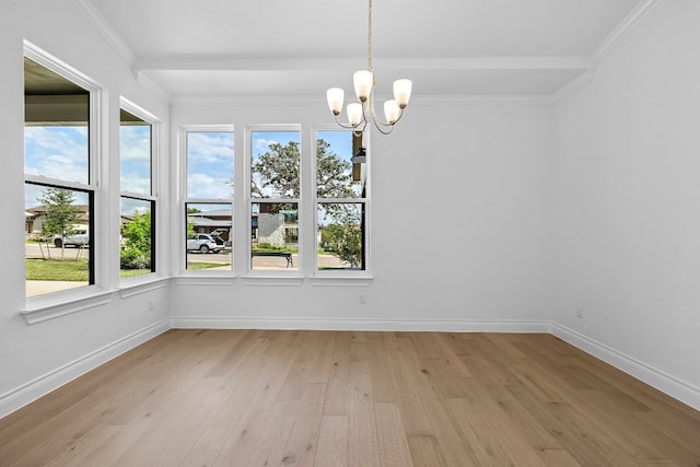 unfurnished dining area featuring a chandelier, light hardwood / wood-style floors, and crown molding