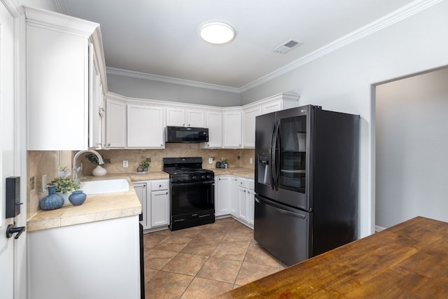 kitchen with sink, backsplash, crown molding, white cabinets, and black appliances