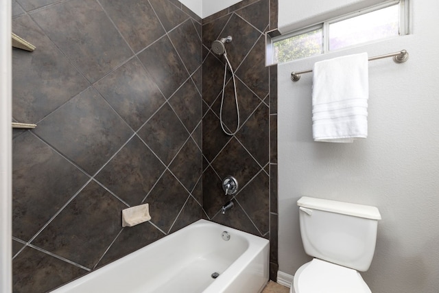 bathroom featuring toilet and tiled shower / bath