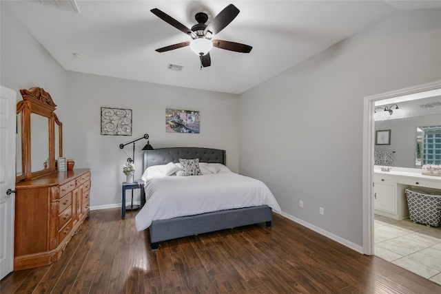 bedroom featuring dark hardwood / wood-style floors, ceiling fan, lofted ceiling, and ensuite bathroom