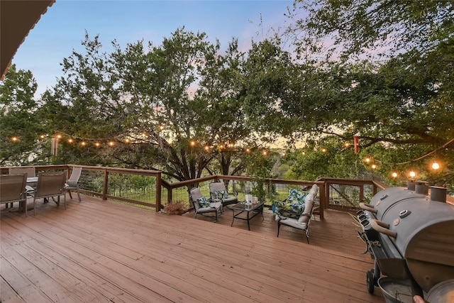 deck at dusk with outdoor lounge area and grilling area