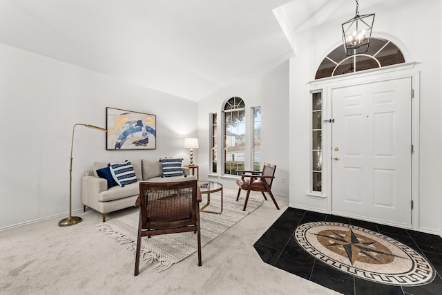 foyer entrance with carpet flooring, vaulted ceiling, and an inviting chandelier