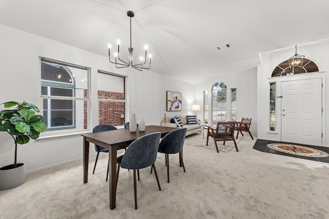 dining room with a notable chandelier, light colored carpet, and vaulted ceiling