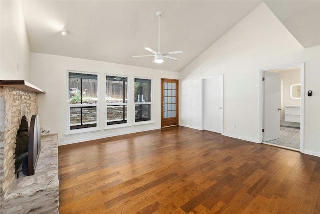 unfurnished living room with a stone fireplace, ceiling fan, high vaulted ceiling, and wood-type flooring